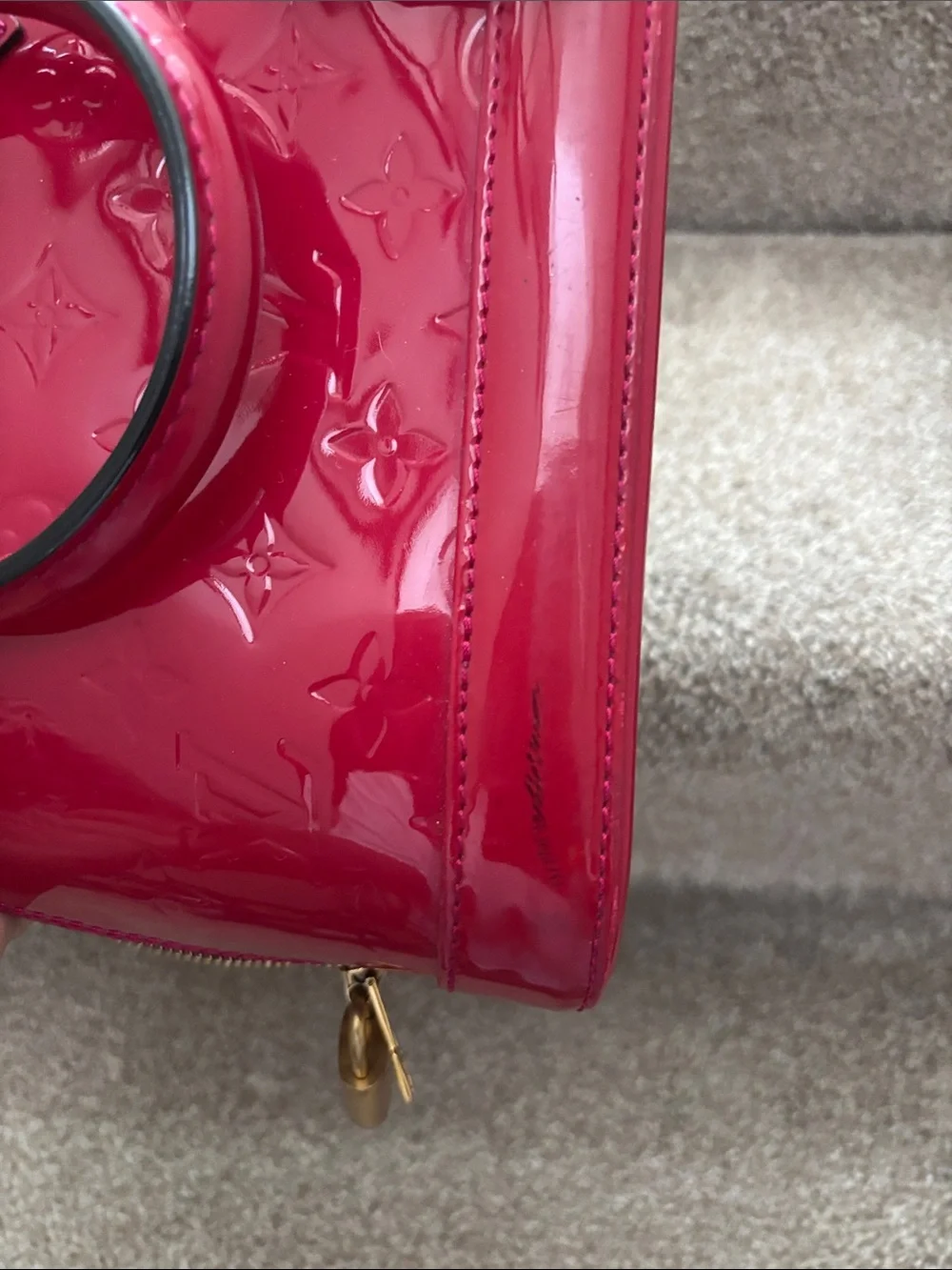 Red Louis Vuitton Alma BB crafted from glossy Monogram Vernis patent leather